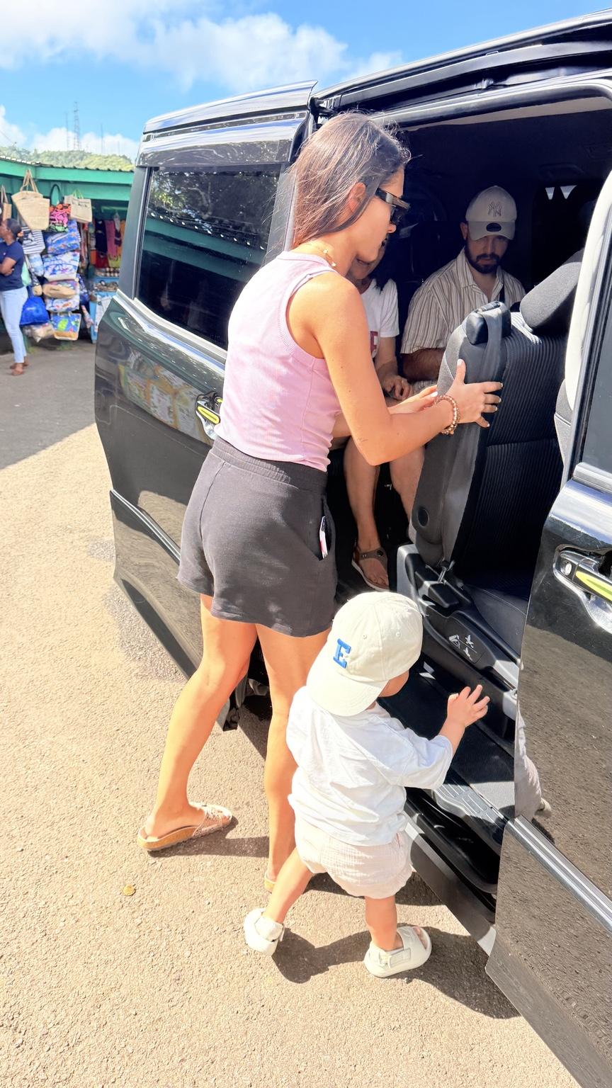 A family entering a black van during pickup